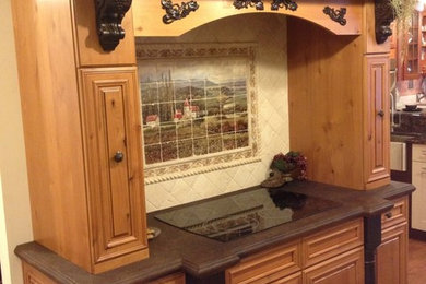 Mid-sized elegant laminate floor kitchen photo in Philadelphia with a farmhouse sink, raised-panel cabinets, light wood cabinets, laminate countertops, white backsplash, ceramic backsplash and black appliances