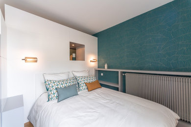 Inspiration pour une petite chambre design avec un mur bleu, parquet clair et un sol beige.