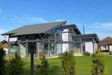 Imagen de fachada de casa gris actual de tamaño medio de dos plantas con tejado de teja de madera