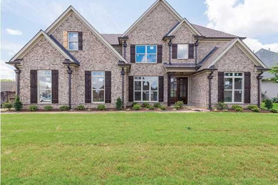 Traditional two-story brick exterior home idea in Other with a hip roof