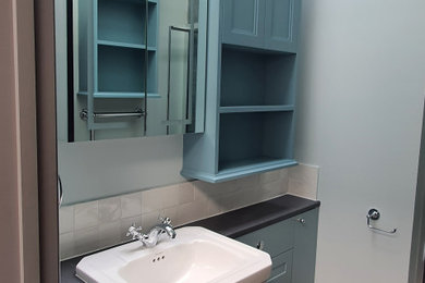 ロンドンにある低価格の小さなコンテンポラリースタイルのおしゃれなバスルーム (浴槽なし) (シェーカースタイル扉のキャビネット、青いキャビネット、造り付け洗面台) の写真