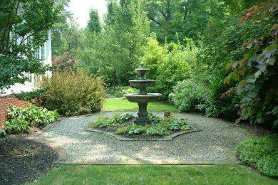 This is an example of a small traditional side yard partial sun garden for spring in Philadelphia with a water feature and gravel.
