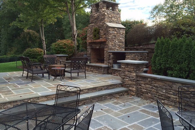 This is an example of a mid-sized arts and crafts backyard patio in Other with a fire feature and natural stone pavers.