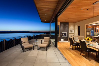 Photo of a large contemporary backyard deck in Seattle with a roof extension.