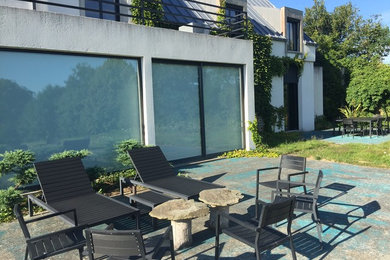 Idée de décoration pour un très grand aménagement d'entrée ou allée de jardin arrière bohème avec une exposition ensoleillée et des pavés en béton.