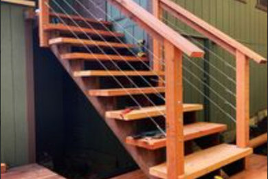 Foto de escalera recta rústica grande con escalones de madera, contrahuellas de madera, barandilla de madera y madera