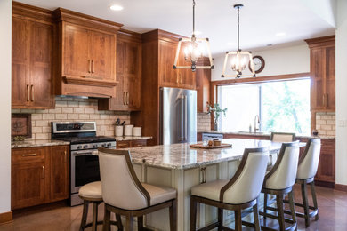 Küche mit Schrankfronten im Shaker-Stil, Granit-Arbeitsplatte, Küchengeräten aus Edelstahl, Betonboden und Kücheninsel in Cedar Rapids