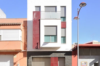 Inspiration for a mid-sized transitional three-storey white exterior in Valencia with mixed siding and a flat roof.