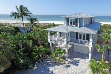 Example of a large beach style blue three-story mixed siding exterior home design in Tampa