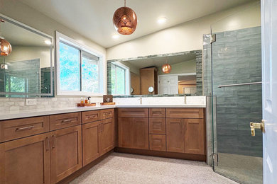 Mid-sized eclectic master blue tile and ceramic tile pebble tile floor, gray floor, double-sink and vaulted ceiling shower bench photo in Los Angeles with shaker cabinets, medium tone wood cabinets, a one-piece toilet, beige walls, an undermount sink, quartzite countertops, a hinged shower door, white countertops and a built-in vanity