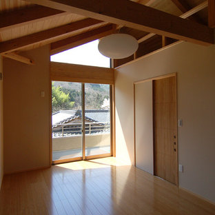 Esempio di una camera matrimoniale etnica con pareti bianche, pavimento in compensato, nessun camino e pavimento beige