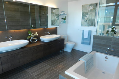 Inspiration for a mid-sized transitional master brown tile and porcelain tile porcelain tile and brown floor bathroom remodel in Vancouver with flat-panel cabinets, brown cabinets, a two-piece toilet, white walls and a hinged shower door