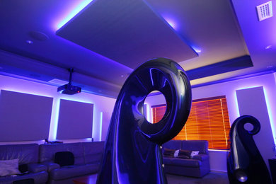 Mid-sized modern enclosed home theatre in Perth with white walls, carpet and a projector screen.