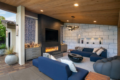 Patio - contemporary concrete paver patio idea in San Francisco with a fireplace and a roof extension