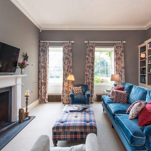 This is an example of a traditional family and games room in Other with grey walls, carpet, a standard fireplace, a wall mounted tv and a stone fireplace surround.