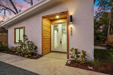 Inspiration for a mid-sized modern white one-story painted brick house exterior remodel in Other with a shed roof and a metal roof