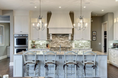 Inspiration for a transitional galley dark wood floor open concept kitchen remodel in Minneapolis with shaker cabinets, white cabinets, gray backsplash, matchstick tile backsplash, stainless steel appliances and an island