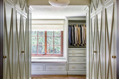 This is an example of a large traditional gender-neutral walk-in wardrobe in Portland with beaded inset cabinets, green cabinets and medium hardwood floors.