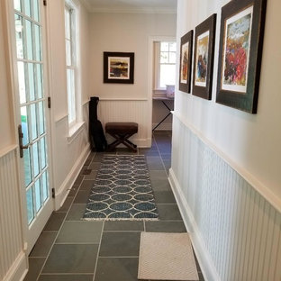 Klassisk inredning av en mellanstor hall, med beige väggar, skiffergolv och grått golv