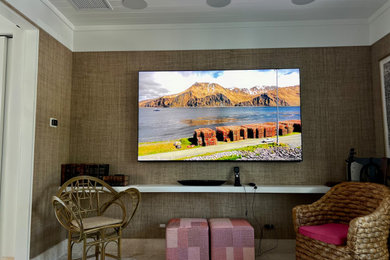 Example of a beach style home theater design in Miami with a wall-mounted tv