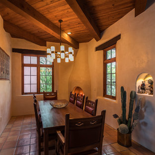 Mediterranes Esszimmer mit weißer Wandfarbe, Terrakottaboden, Eckkamin und rosa Boden in Phoenix