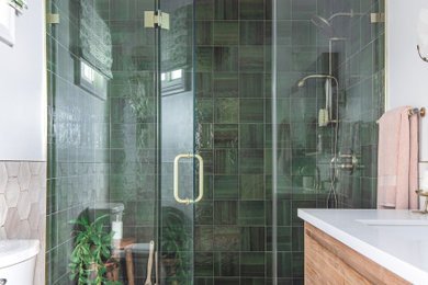 Источник вдохновения для домашнего уюта: главная ванная комната среднего размера в современном стиле с плоскими фасадами, светлыми деревянными фасадами, раздельным унитазом, зеленой плиткой, керамогранитной плиткой, белыми стенами, полом из керамогранита, монолитной раковиной, столешницей из искусственного кварца, серым полом, душем с распашными дверями, белой столешницей, тумбой под одну раковину и напольной тумбой