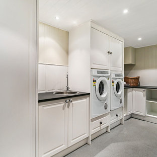 Foto di un'ampia sala lavanderia vittoriana con lavello da incasso, ante in stile shaker, ante bianche, top in laminato, paraspruzzi bianco, paraspruzzi con piastrelle in ceramica, pareti beige, pavimento in vinile, lavatrice e asciugatrice affiancate, pavimento grigio, top nero, soffitto in perlinato e pareti in perlinato
