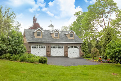 Example of a large classic detached three-car garage design in Other