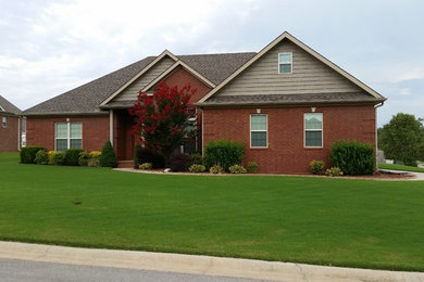 Mid-sized elegant red one-story brick gable roof photo in Other