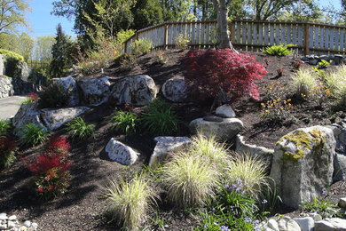 This is an example of a mid-sized transitional full sun front yard stone landscaping in Seattle for summer.