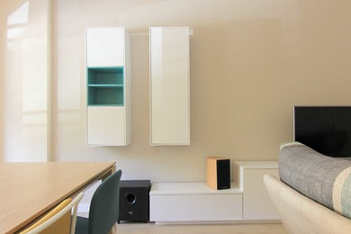 Modelo de salón abierto escandinavo grande con paredes beige, suelo laminado y pared multimedia