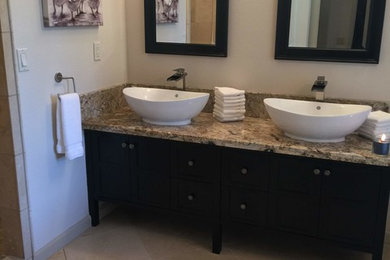Photo of a large transitional master bathroom in Sacramento with shaker cabinets, dark wood cabinets, a freestanding tub, a double shower, a one-piece toilet, beige walls, travertine floors, a vessel sink, granite benchtops, beige floor and an open shower.
