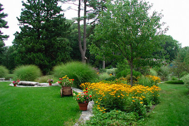 This is an example of a large traditional partial sun backyard stone landscaping in New York.