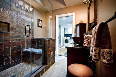 Large elegant master stone tile ceramic tile corner shower photo in Huntington with furniture-like cabinets, dark wood cabinets, a one-piece toilet, a vessel sink, marble countertops and beige walls