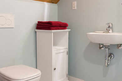 Example of a small trendy 3/4 black and white tile and mosaic tile ceramic tile corner shower design in Vancouver with furniture-like cabinets, white cabinets, a wall-mount toilet, blue walls and a wall-mount sink