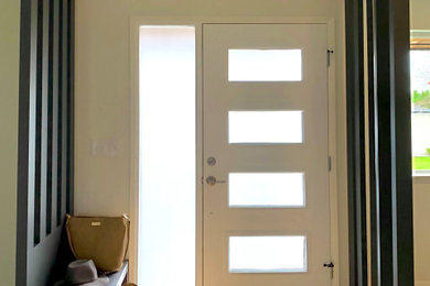 Example of a small trendy light wood floor entryway design in Seattle with a white front door