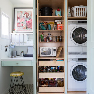 Bohemian utility room in Los Angeles with a stacked washer and dryer and multi-coloured floors.
