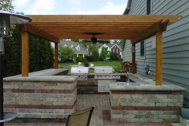This is an example of a large transitional backyard patio in Columbus with an outdoor kitchen, brick pavers and a pergola.