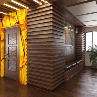 Design ideas for a large modern home studio in Other with white walls, medium hardwood flooring, a standard fireplace, a metal fireplace surround, a built-in desk and brown floors.