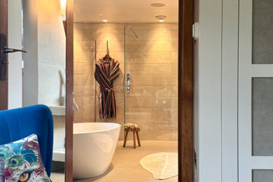Inspiration for a large modern grey and white ensuite half tiled bathroom in London with a freestanding bath, a walk-in shower, a wall mounted toilet, beige tiles, porcelain tiles, beige walls, porcelain flooring, a vessel sink, marble worktops, beige floors, an open shower, white worktops, double sinks and a floating vanity unit.