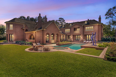 Photo of a large traditional full sun backyard stone landscaping in Houston.