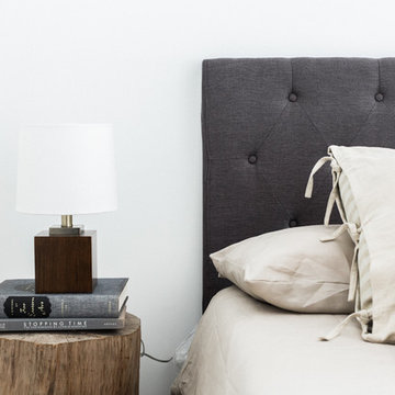 Tree Trunk Nightstand with Gray Tufted Headboard, Kilim Pillows and Wood Lamp