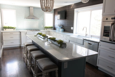 Kitchen - mid-sized farmhouse dark wood floor and brown floor kitchen idea in Cincinnati with a farmhouse sink, raised-panel cabinets, white cabinets, granite countertops, green backsplash, ceramic backsplash, stainless steel appliances, an island and green countertops