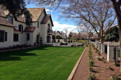 This is an example of an expansive traditional front yard shaded formal garden in Phoenix with brick pavers.
