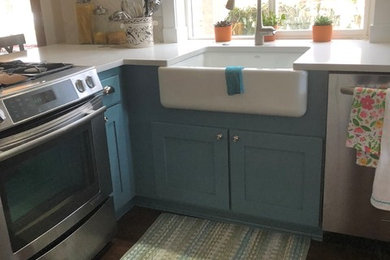 Kitchen pantry - mid-sized coastal l-shaped laminate floor and brown floor kitchen pantry idea in Seattle with a farmhouse sink, shaker cabinets, turquoise cabinets, quartzite countertops, white backsplash, mosaic tile backsplash, stainless steel appliances, a peninsula and white countertops