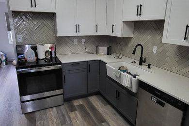 Large minimalist light wood floor and gray floor kitchen photo in Denver with a farmhouse sink, shaker cabinets, blue cabinets, quartzite countertops, gray backsplash, ceramic backsplash, stainless steel appliances and white countertops