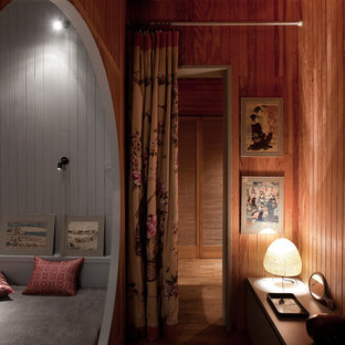 Ispirazione per una piccola camera degli ospiti etnica con pareti marroni e pavimento in legno massello medio