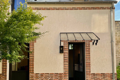 Réalisation d'une petite façade de maison urbaine en brique à un étage avec un toit en métal et un toit gris.