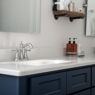 Clean White Bathroom with Pop of Blue cabinet and Gold pulls