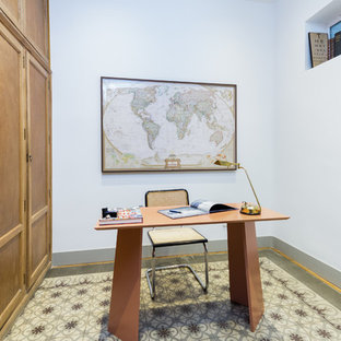 Modelo de despacho mediterráneo con escritorio independiente, paredes blancas, suelo de baldosas de cerámica y suelo multicolor